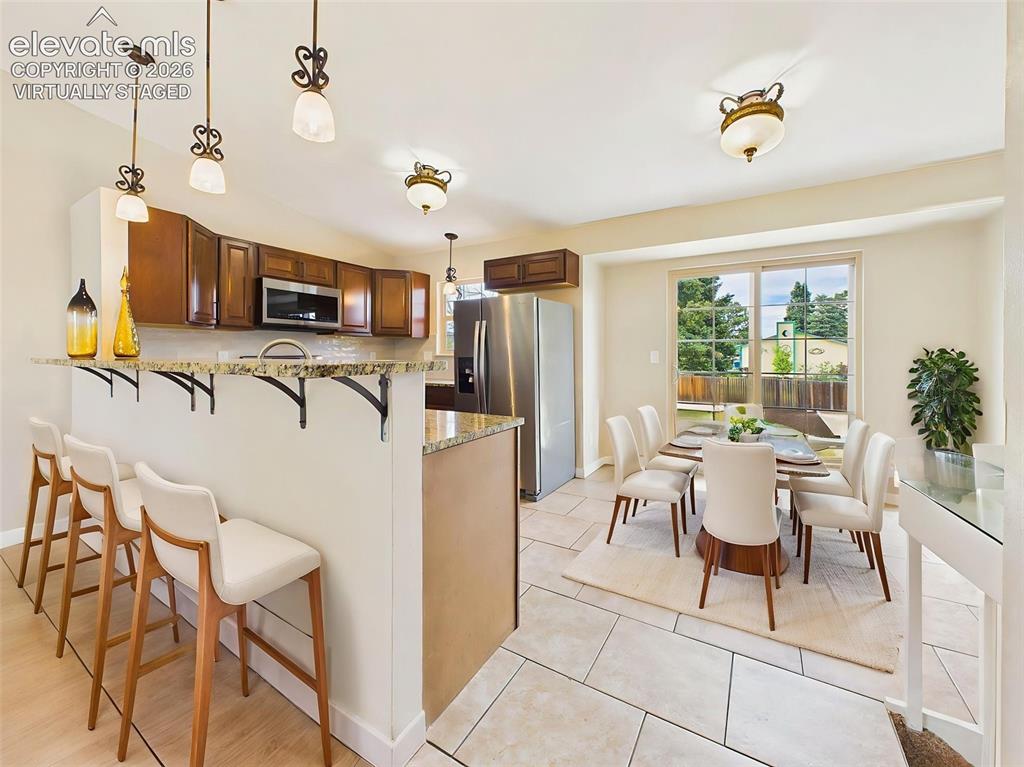 Image 14 of 50: Virtually staged dining area highlights the home’s open-concept layout, fea