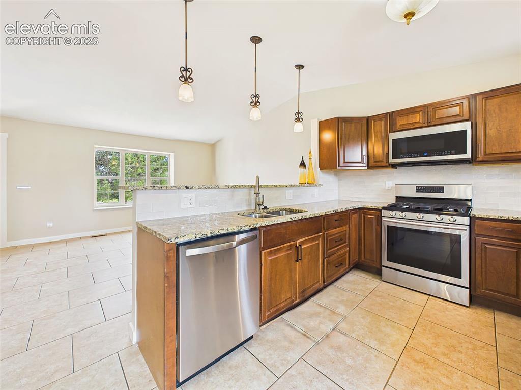 Image 16 of 50: Open-concept kitchen seamlessly connected to the main living area, featurin
