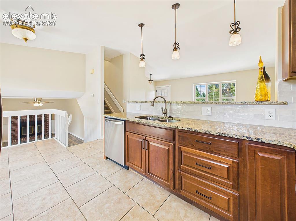 Image 19 of 50: Open-concept kitchen with granite countertops, stainless steel appliances,