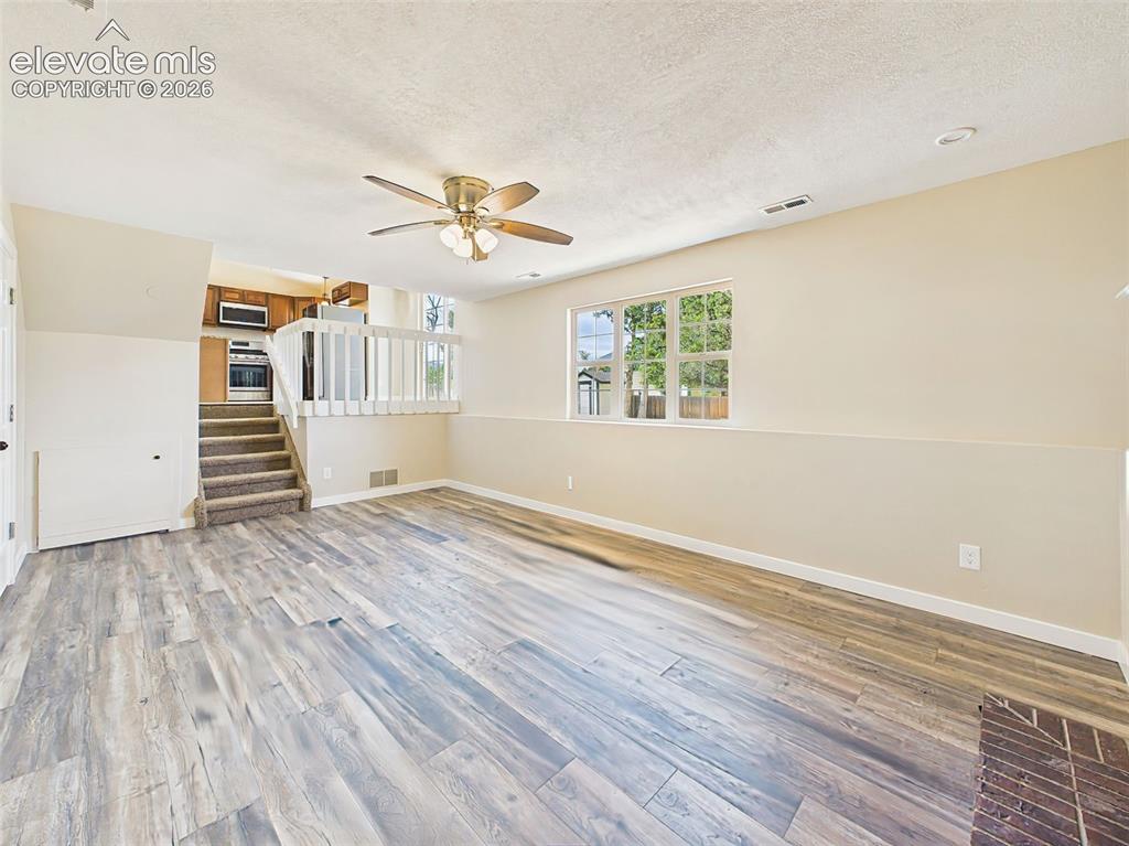 Image 22 of 50: Expansive lower-level family room with luxury vinyl plank flooring, large p