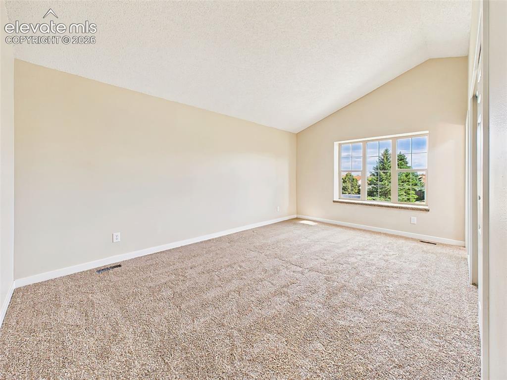 Image 24 of 50: Escape to this oversized primary suite featuring soaring vaulted ceilings,