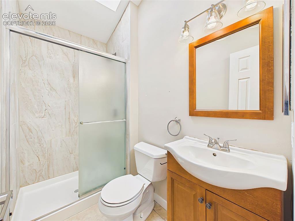 Image 29 of 50: Updated primary bathroom featuring a tiled shower surround, glass shower do