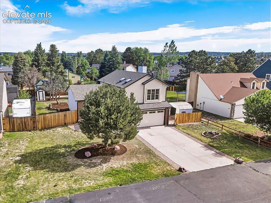 Image 4 of 50: Elevated view showcasing the spacious lot, mature trees, extended driveway,