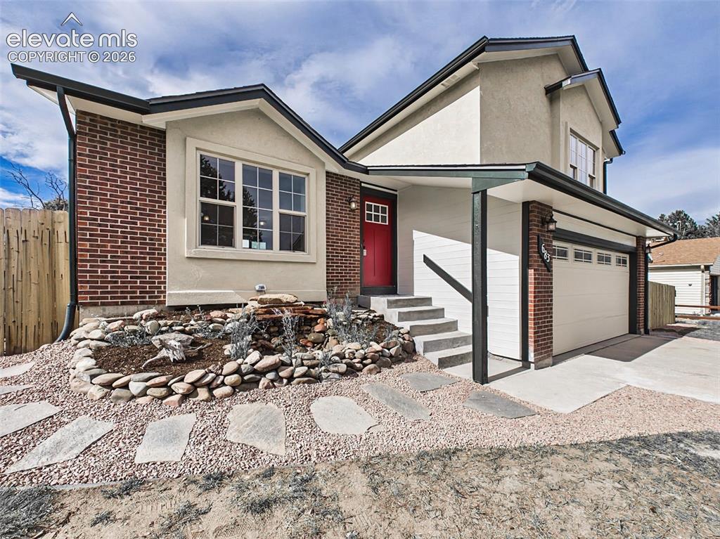 Image 9 of 50: Thoughtfully designed curb appeal showcases a custom water feature, profess