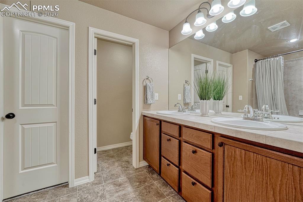 Image 11 of 41: Elegant primary bath featuring dual vanities and a fresh, modern look.