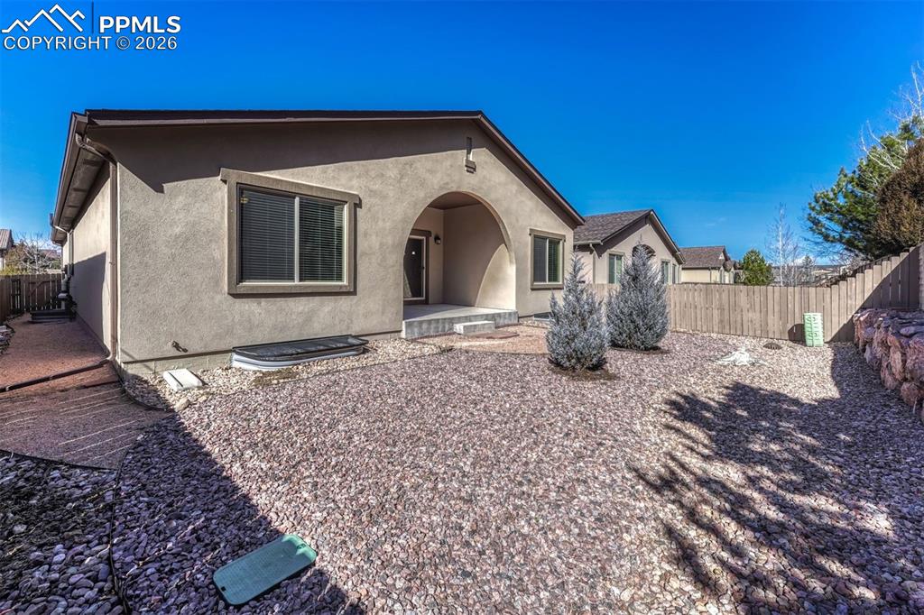 Image 26 of 41: Fenced backyard with low-maintenance, xeriscaped, landscaping — perfect for