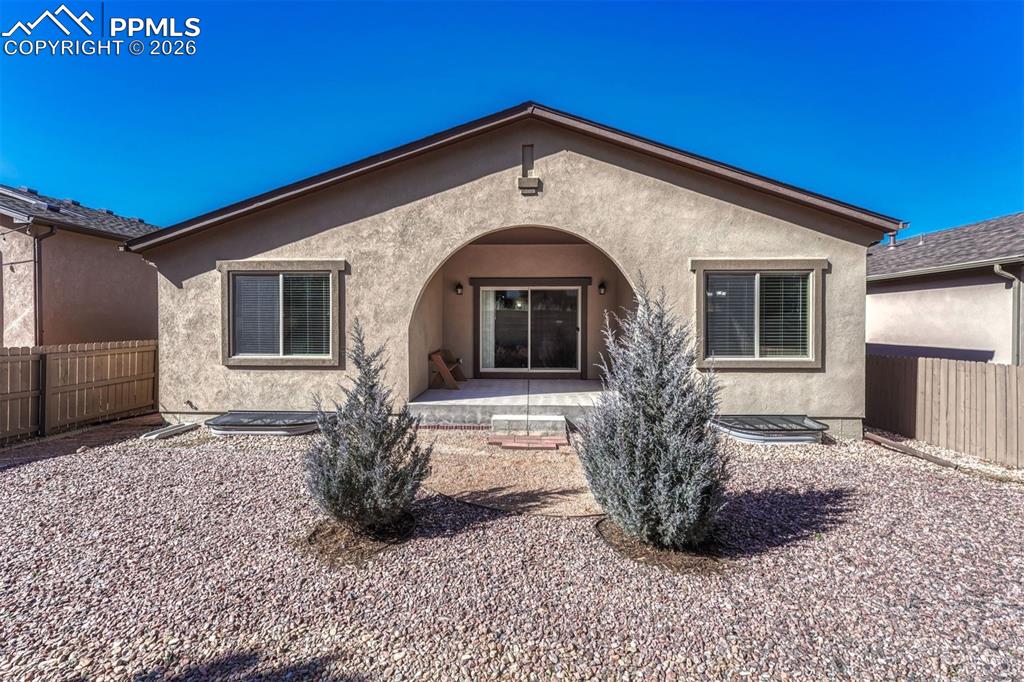 Image 36 of 41: Fenced backyard with xeriscaped, landscaping for easy, low-maintenance livi