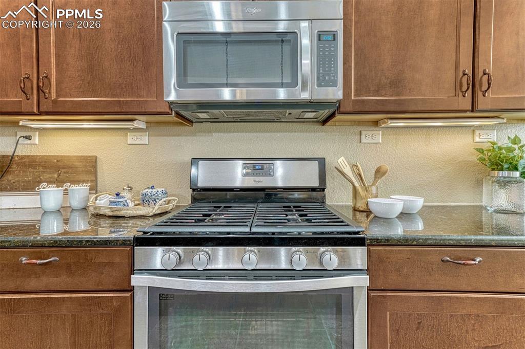 Image 5 of 41: Stainless steel appliances, gas oven, and large walk-in pantry.