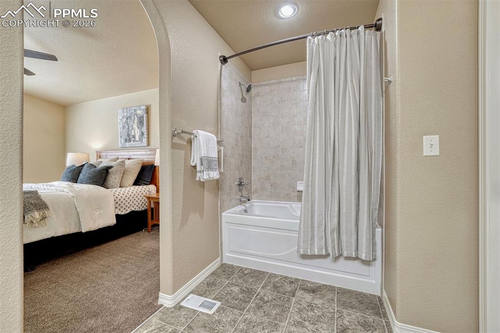 Image 9 of 41: Main-level primary suite with walk-in closet and private bath.