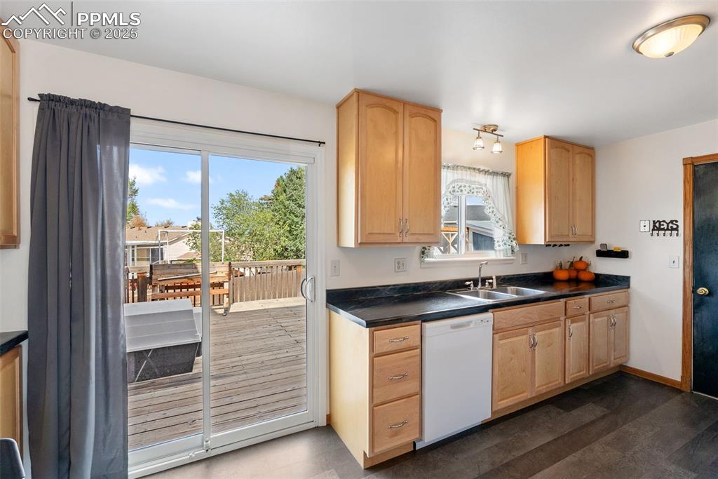 Image 10 of 42: With lighter warm colored cabinets, the kitchen feels large and spacious.