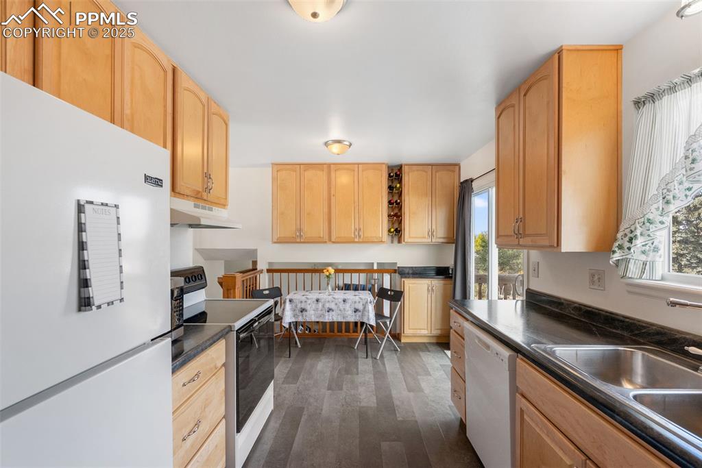 Image 13 of 42: Look out over the backyard while preparing meals and enjoy them at the near