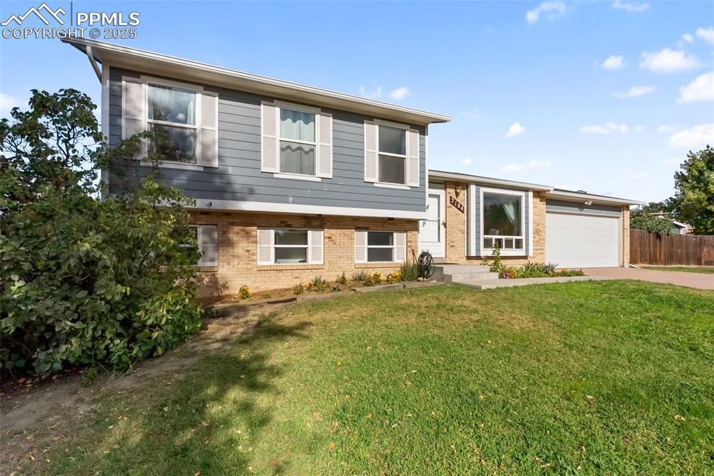 Image 2 of 42: This tri level offers a good sized and landscaped front yard