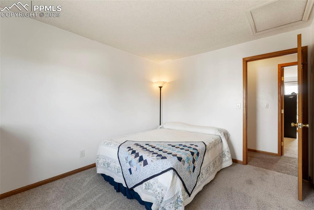 Image 24 of 42: Upper level third bedroom with new carpet and attic access