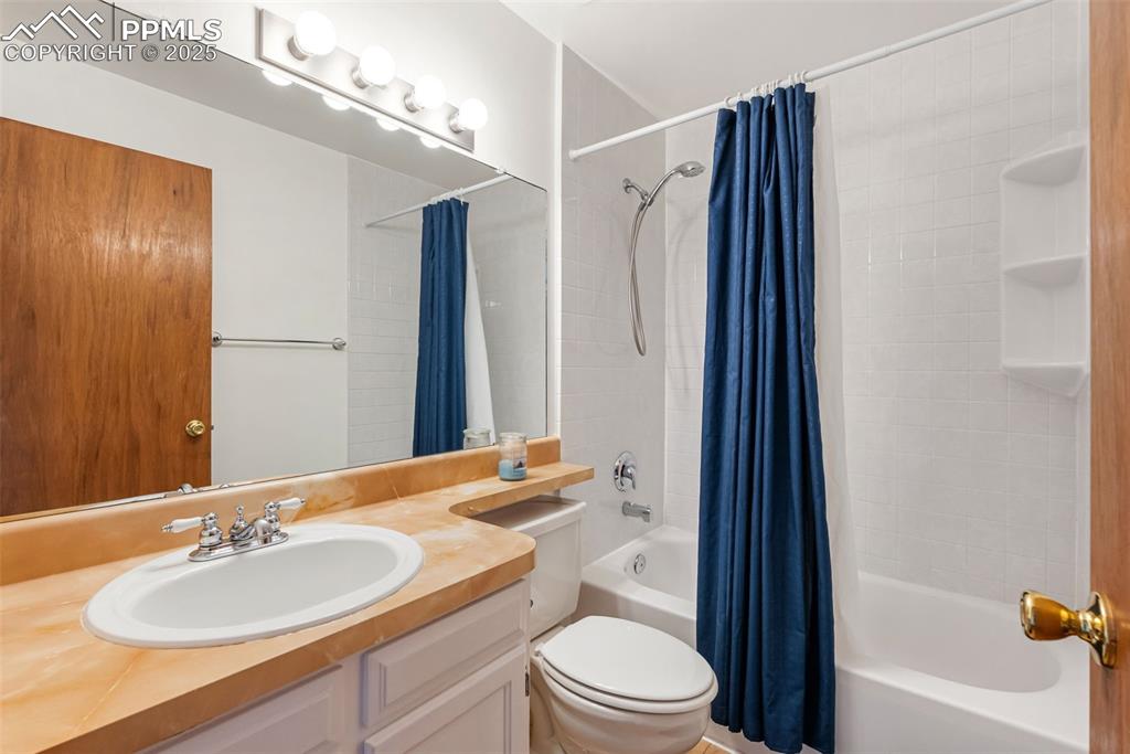 Image 31 of 42: The upper level bathroom features a vanity with banjo style countertop and
