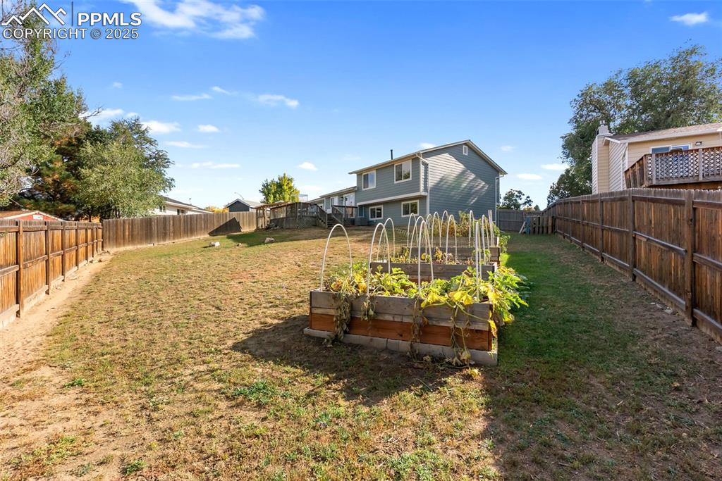 Image 38 of 42: At the far corner of the yard are four raised garden beds for your very own