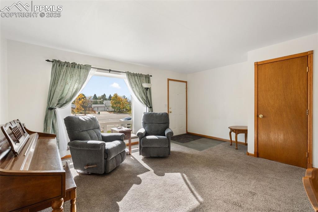 Image 4 of 42: Main level living room with carpet and luxury vinyl flooring for the entry.