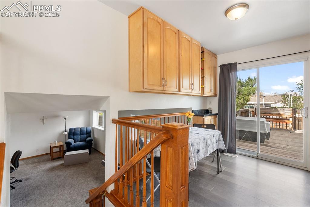 Image 8 of 42: Just past the stairs is the kitchen and second dining space with walkout ac