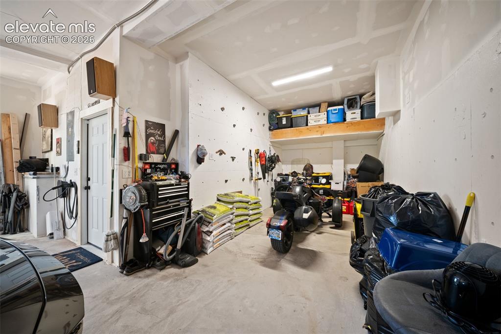 Image 27 of 42: 3 car attached heated tandem garage with storage and rock climbing wall