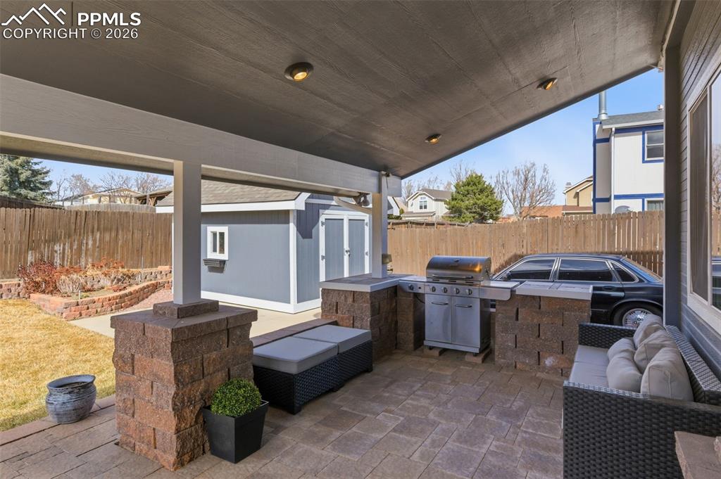 Image 39 of 44: A built-in BBQ grill; vaulted ceiling; and beautiful stone tile work makes 