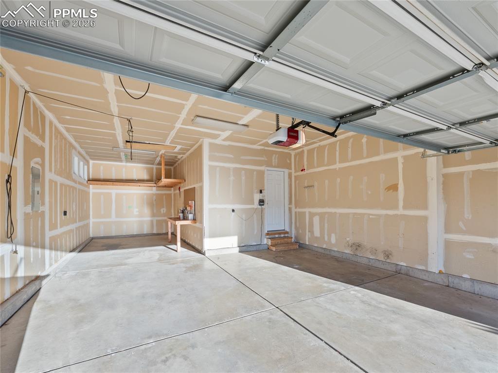 Image 18 of 46: Garage with a garage door opener and electric panel