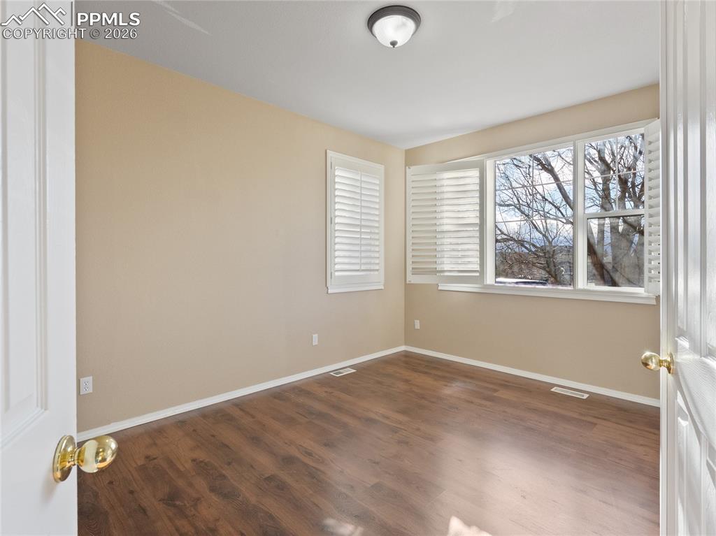 Image 20 of 46: Officewith dark wood-style flooring and baseboards