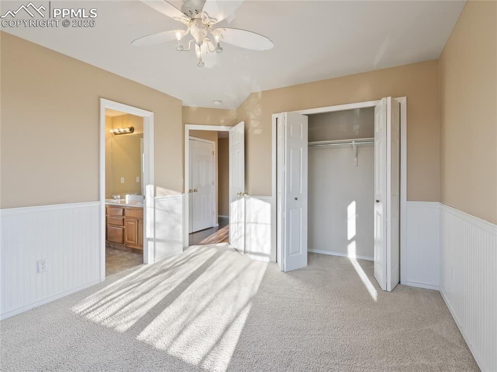 Image 33 of 46: Unfurnished bedroom featuring a wainscoted wall, light carpet, a ceiling fa