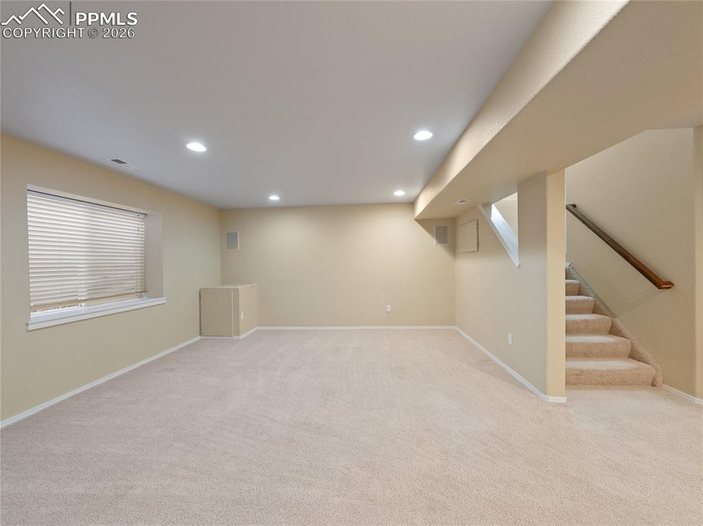 Image 37 of 46: Below grade area with light colored carpet and recessed lighting