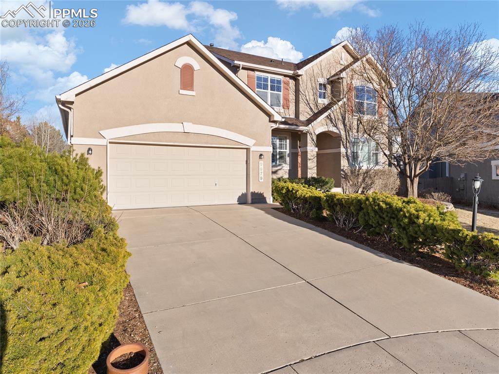Image 45 of 46: View of front of property with concrete driveway, stucco siding, an attache