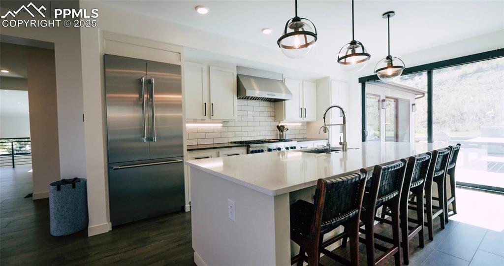 Image 3 of 12: Kitchen featuring white cabinetry, stainless steel appliances, a breakfast
