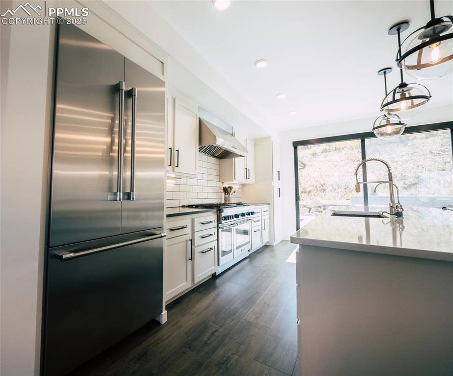 Image 4 of 12: Kitchen featuring white cabinetry, stainless steel appliances, a breakfast