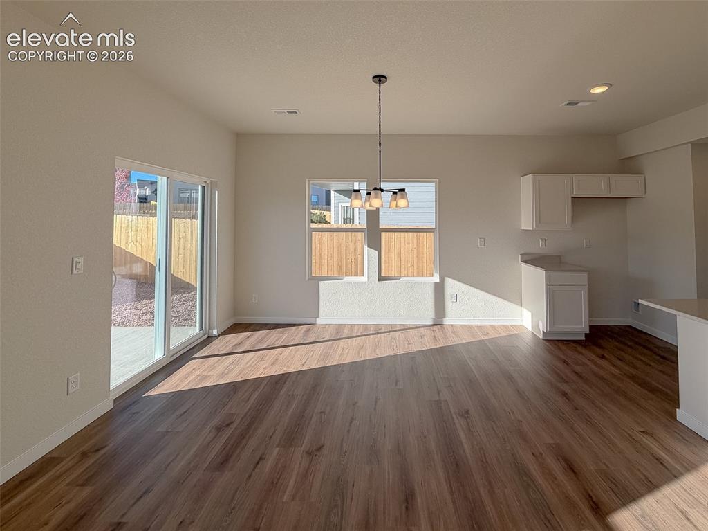 Image 11 of 34: Wood-finish flooring, recessed ceiling lighting, sliding glass door, white
