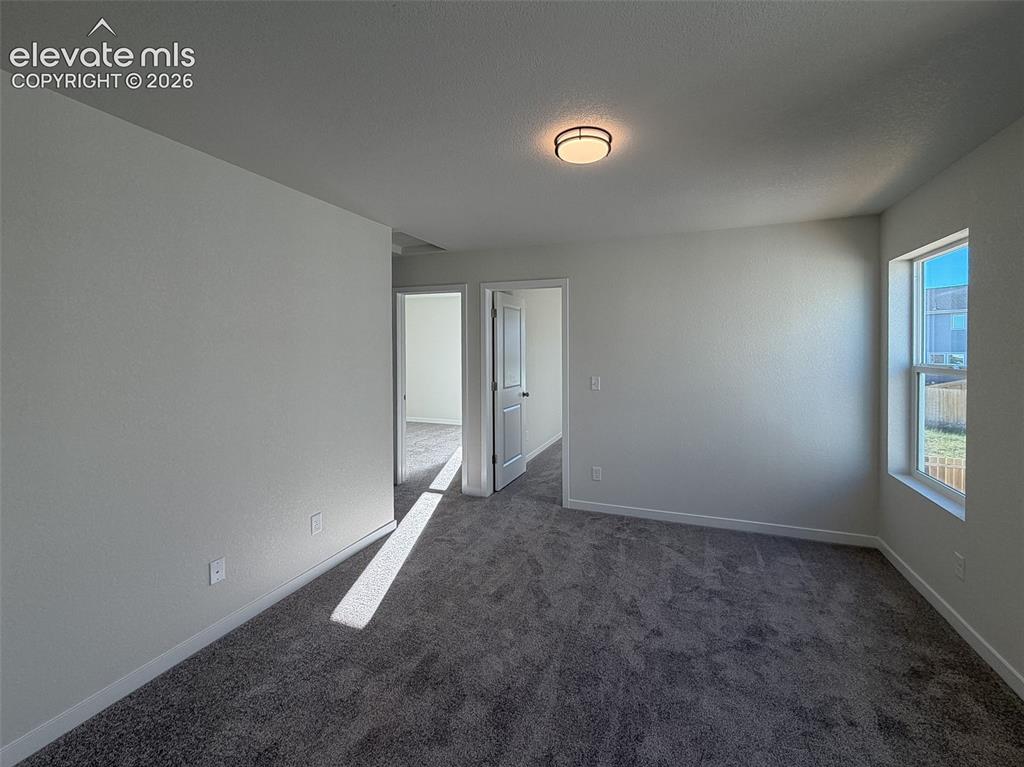 Image 13 of 34: Neutral wall paint, textured ceiling, carpeted flooring, and a flush mount