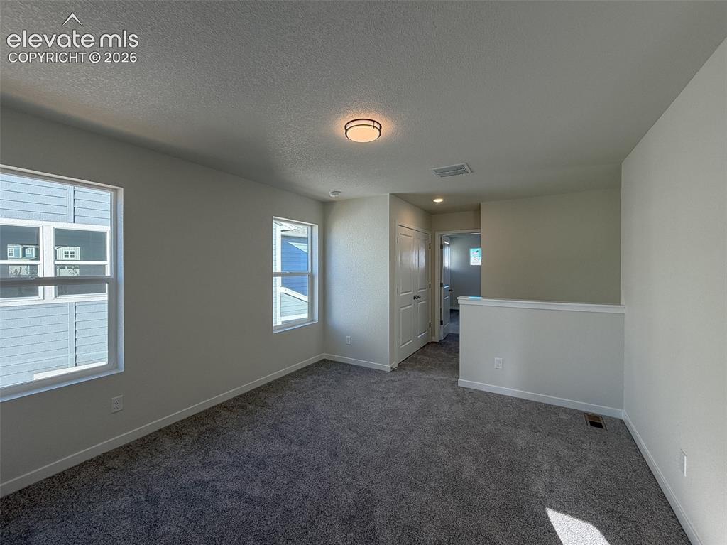 Image 15 of 34: Neutral wall tones, gray carpeting, and two pane windows