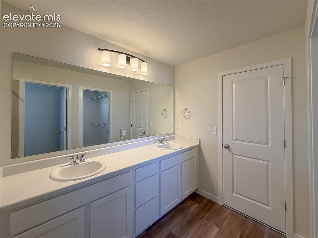 Image 22 of 34: Dual vanity with integrated sinks, expansive wall-mounted mirror, five-ligh