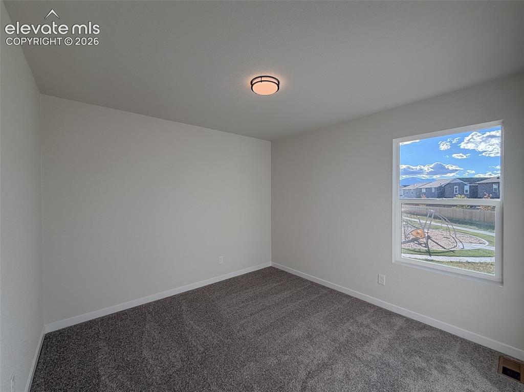 Image 25 of 34: Window with white trim, gray carpet, white walls, and a ceiling-mounted lig