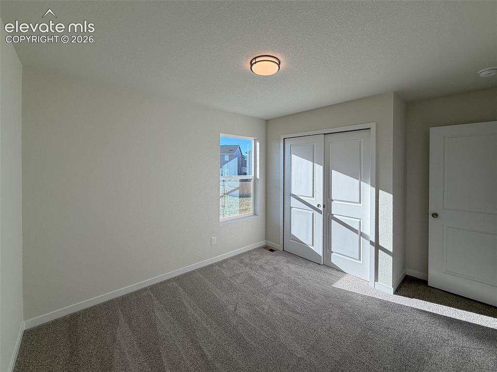 Image 28 of 34: Neutral wall paint, ceiling-mounted light fixture, sliding closet doors, wi