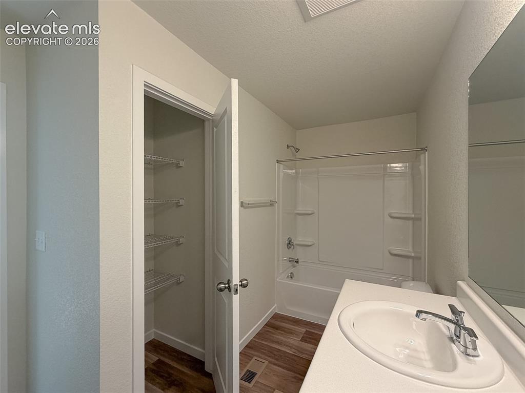 Image 29 of 34: White vanity with integrated sink, chrome faucet, white bathtub with integr