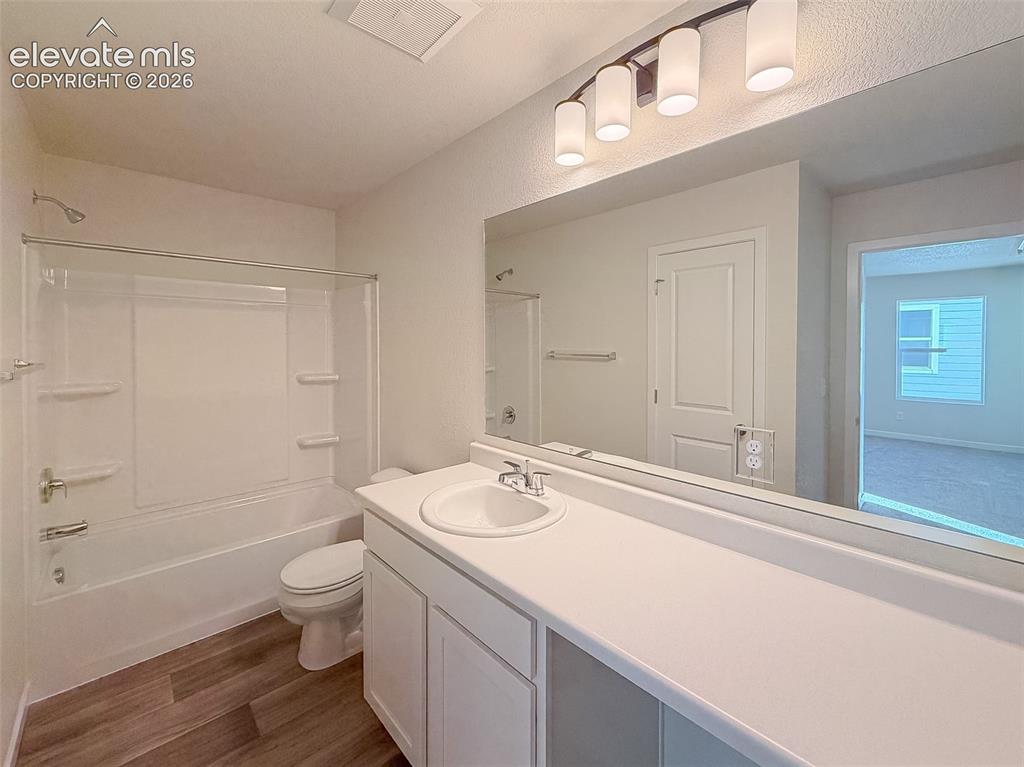 Image 30 of 34: Single vanity with an integrated sink, full-width mirror, and a four-light