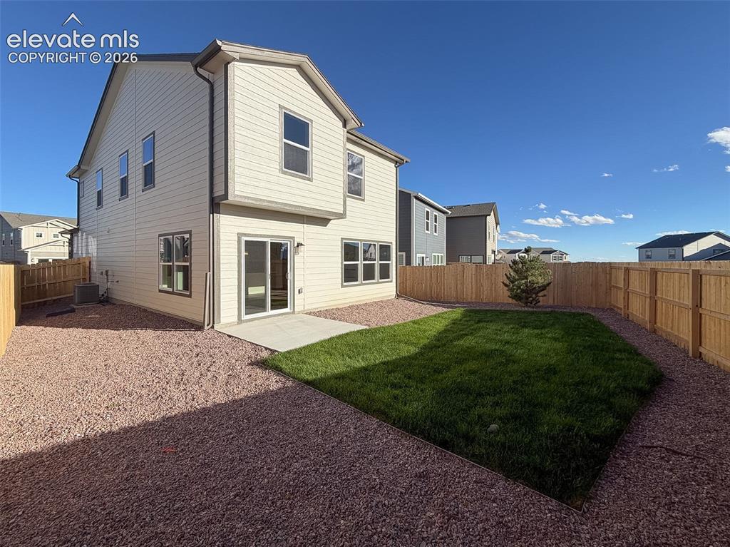 Image 33 of 34: Private backyard featuring a concrete patio, sliding glass door, manicured