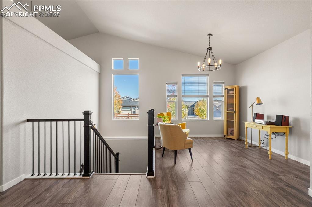 Image 15 of 48: Living area featuring an upstairs landing, dark wood-style floors, lofted c
