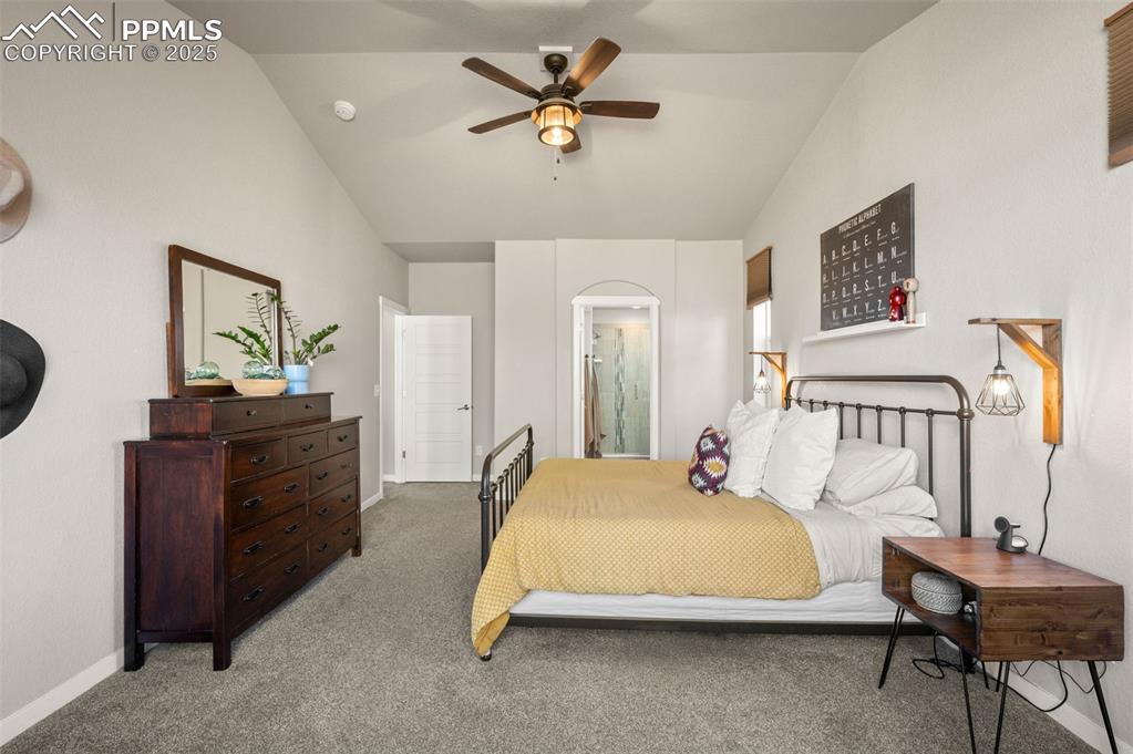 Image 19 of 48: Carpeted bedroom featuring vaulted ceiling, ensuite bathroom, and ceiling f