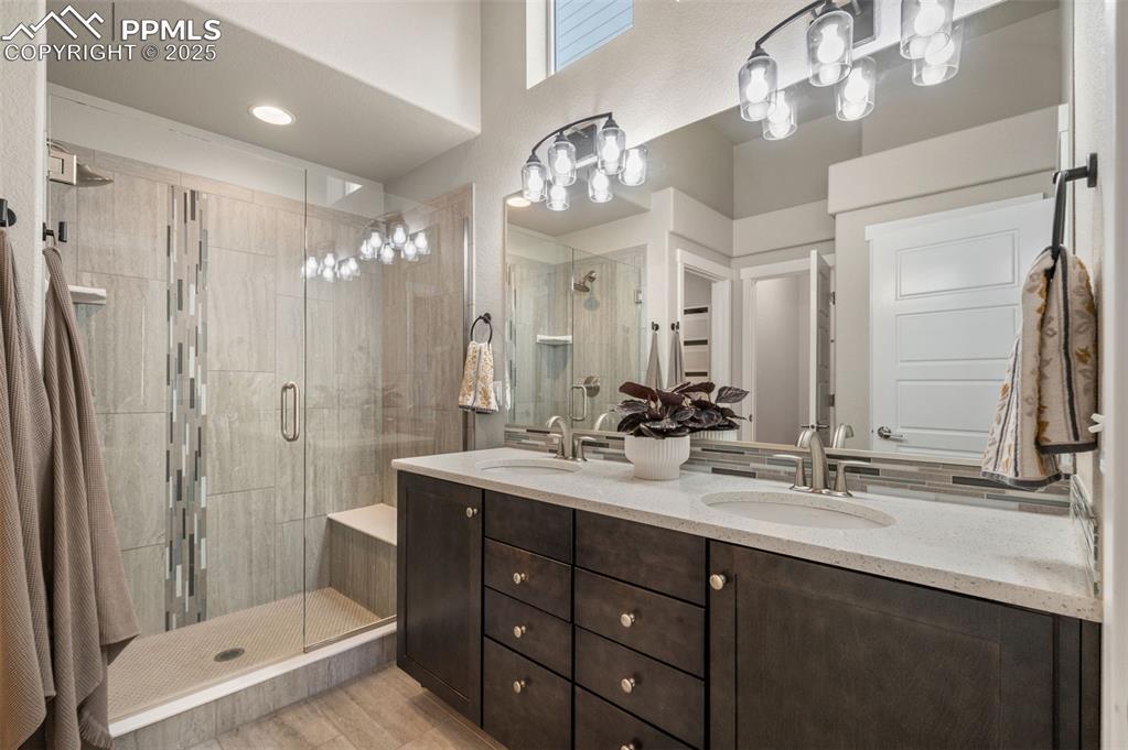 Image 21 of 48: Full bathroom featuring double vanity and a shower stall