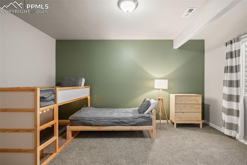 Image 24 of 48: Carpeted bedroom featuring beamed ceiling and baseboards