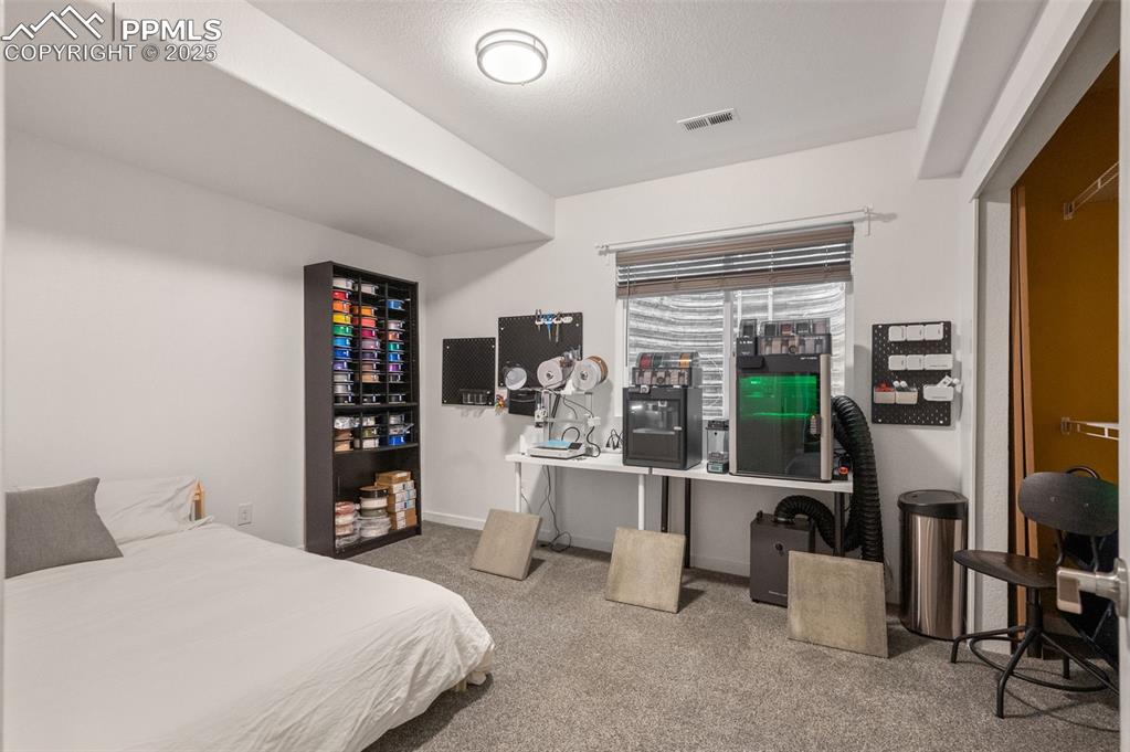 Image 32 of 48: Bedroom with light colored carpet and a textured ceiling