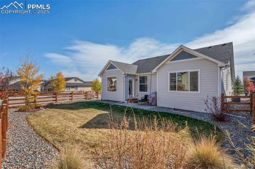 Image 40 of 48: View of front of home featuring a shingled roof, a patio, and a fenced back