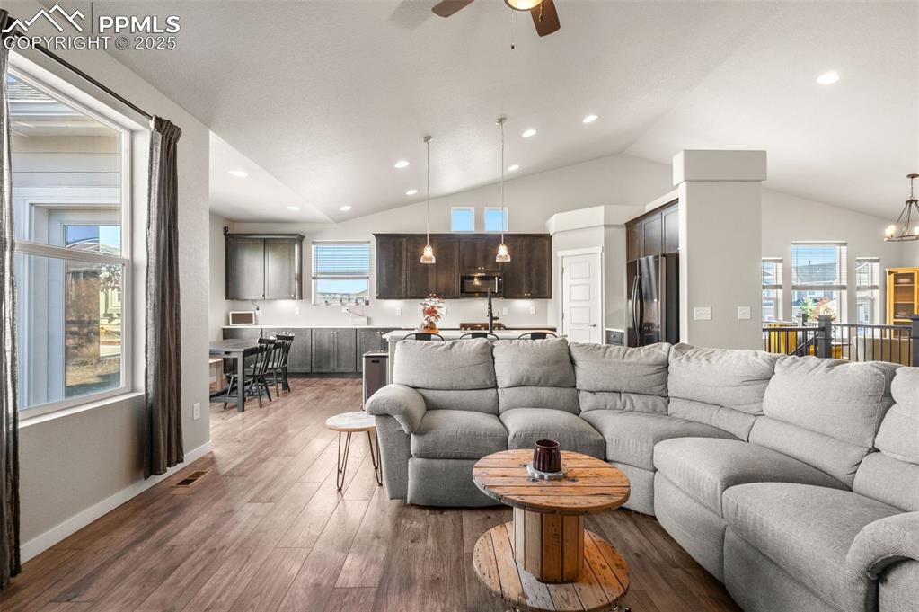 Image 6 of 48: Living area with a chandelier, dark wood-style floors, healthy amount of na