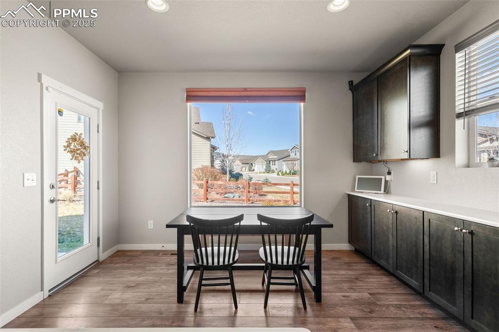 Image 8 of 48: Dining room with dark wood-style floors and recessed lighting