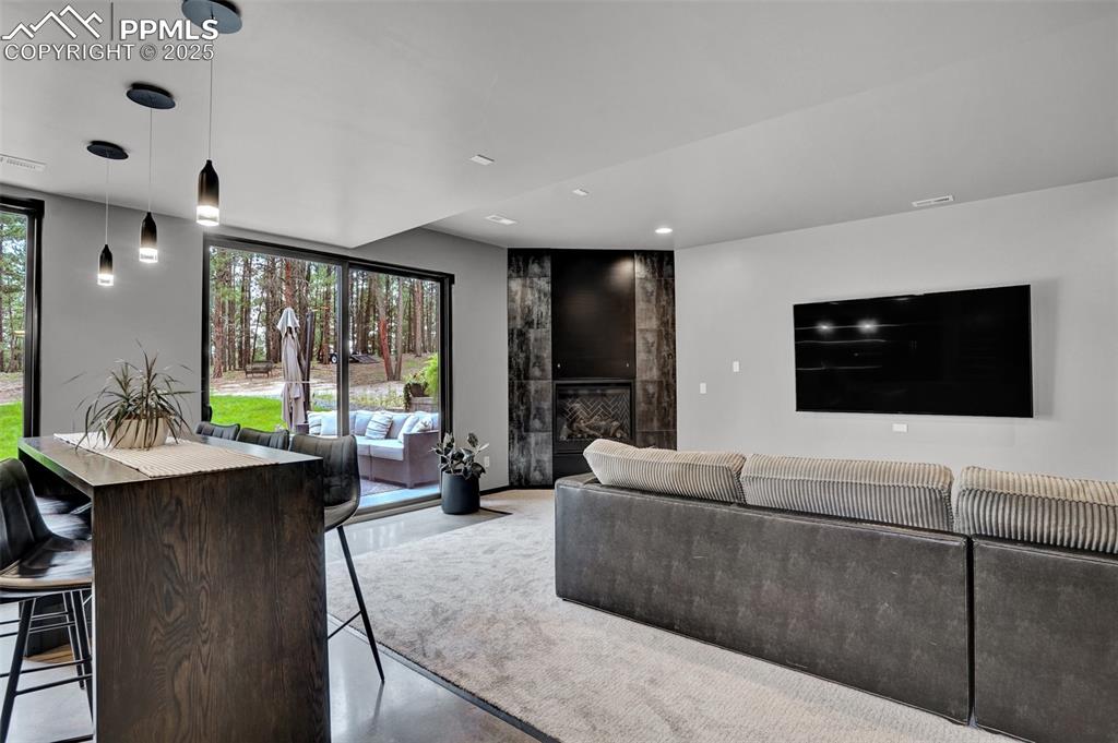 Image 13 of 36: Entertainment zone! Full walk behind bar, fireplace, walkout to the yard an