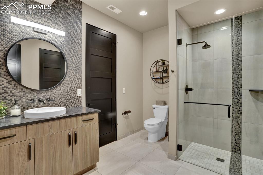 Image 16 of 36: 3/4 bath with custom zero entry shower serves the entertainment area and al
