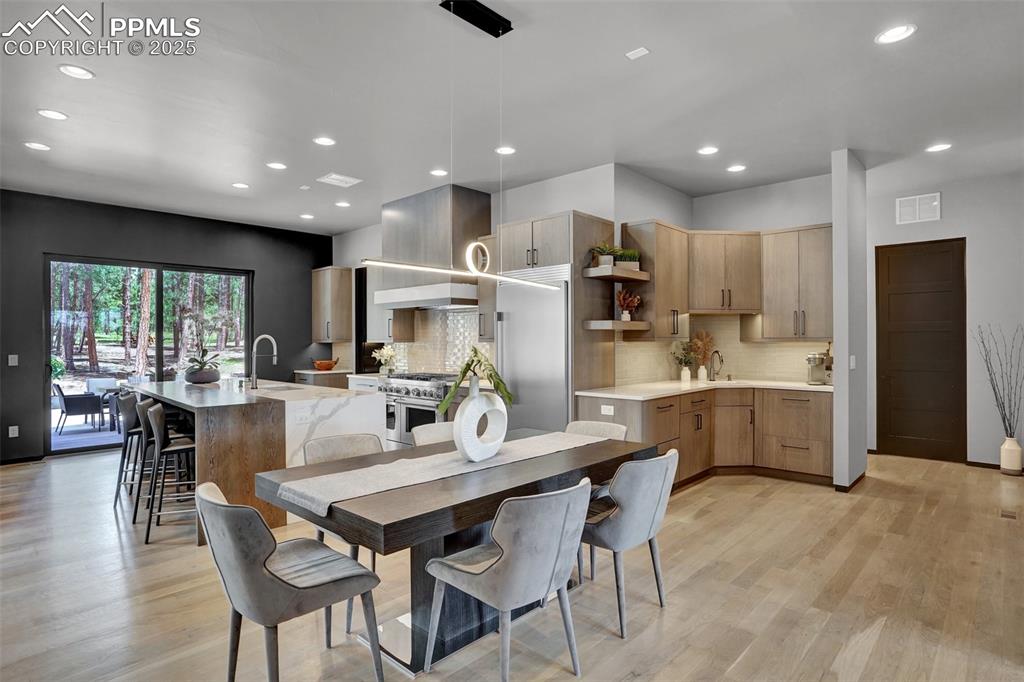 Image 7 of 36: Innovative walk-up bar off to the side of the kitchen allows for uniteruted